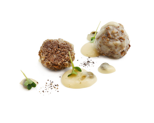 Vegane Königsberger Klopse veganer Hackbällchenersatz auf Weizenproteinbasis in Kapernsauce, abgeschmeckt mit Zitrone.