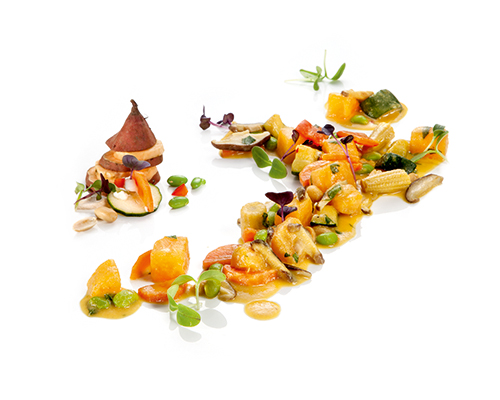 Süßkartoffelpfanne mit Süßkartoffelwürfeln, Mais, Karotten und Erdnüssen, in Kokosmilch und Chilisauce.