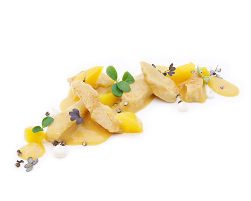 Sliced chicken breast in peach sauce with peach slices.