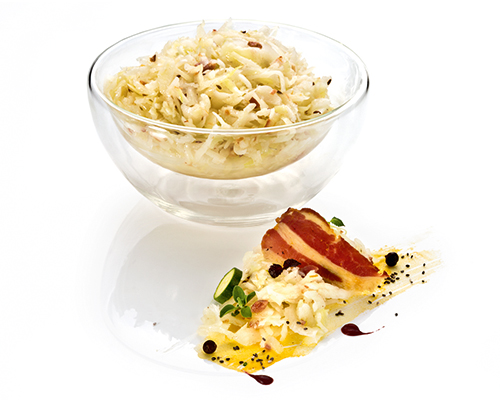 Bayrischer Krautsalat mit Weißkraut, mit gebratenem Speck und Kümmel, in Essig-Öl-Dressing.