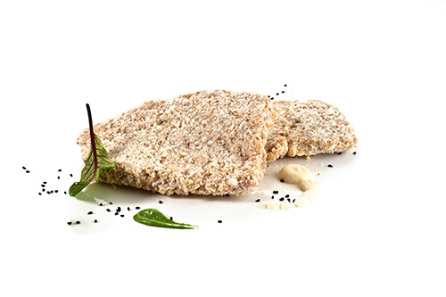 Wirtshaus-Schnitzel aus der Putenbrust, roh, paniert mit einer Mischung aus Laugenbrot, Senf und Zwiebeln.