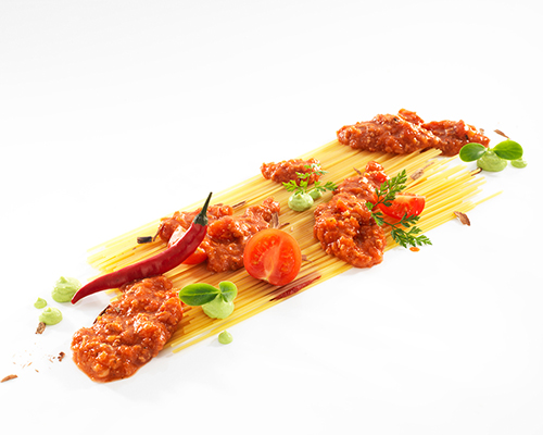 Putenbolognaise aus Putenfleisch, mit Karotten- und Selleriewürfeln.