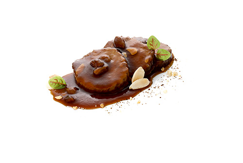 Veganer Seitan nach Sauerbraten-Art auf Weizenproteinbasis, mit Mandeln und Rosinen, in typischer Sauce, in Scheiben geschnitten.