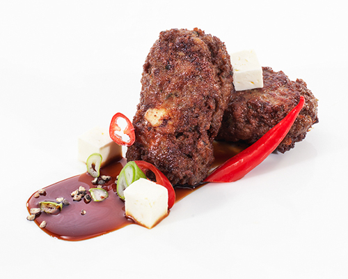 Bifteki made from beef, fried in a pan.