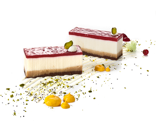 Butterkeks-Schmand-Schnitte Schmandcreme auf Knusper-Butterkeks-Boden, mit Erdbeer-Himbeer-Spiegel, 3 x 7 cm.