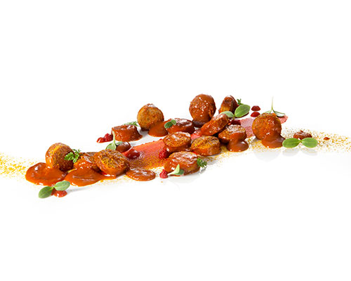 Pork currywurst in a fruity, spicy sauce with cola and apple sauce.