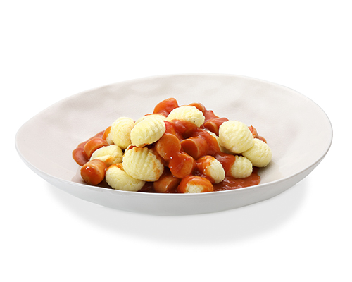 Wurstgulasch mit Gnocchi Geflügelwiener in Scheiben, in herzhafter Tomatensauce.
