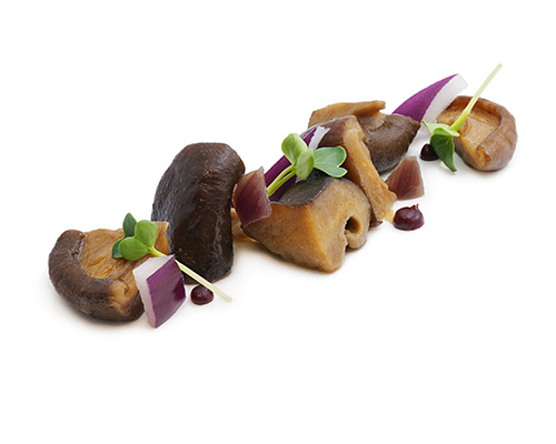 Shiitakepilze mit Balsamico mit hellem Balsamicoessig und roten Zwiebeln, verfeinert mit Olivenöl.