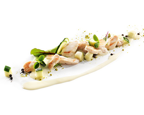 Sliced chicken breast in cheese sauce with salsify and courgettes.