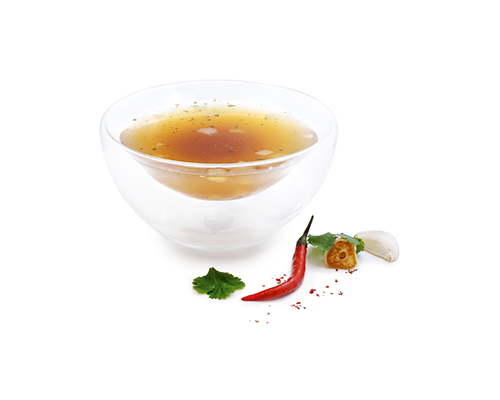 Vegetable-based ramen broth with a garnish of onions, ginger, garlic, chilli and coriander.