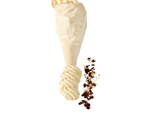 Weiße Mousse au Chocolat im Spritzbeutel.