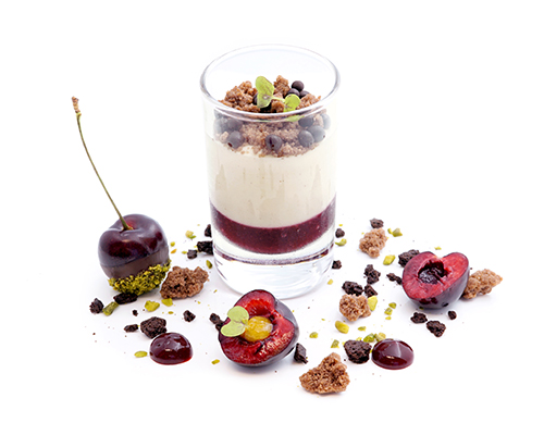 Schwarzwälder Kirsch "Winter Time" Kirschsauce, weiße Mousse mit Kirschwasser und winterlichen Gewürzen, ausgarniert mit knusprigen  Schokoladenstreuseln und Schokoladenperlen, im Island-Glas.