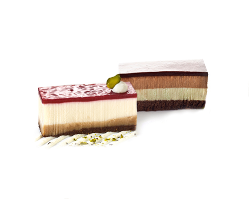 Mischkiste Butterkeks-Schmand-Schnitte und Mozart-Symphonie Butterkeks-Schmand-Schnitte Schmandcreme auf Knusper-Butterkeks-Boden, mit Erdbeer-Himbeer-Spiegel  und Mozart-Symphonie Nougat- und Pistazienmousse auf Schokoladenbiskuit, 3 x 7 cm. 3 x 7 cm.