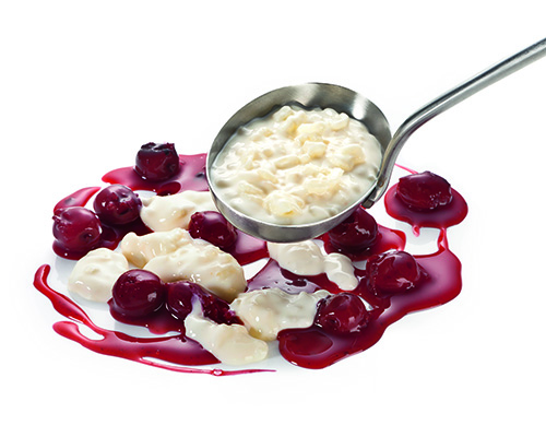 Milchreis mit einer Zuckerart und Süßungsmittel, mit Kirschgrütze.