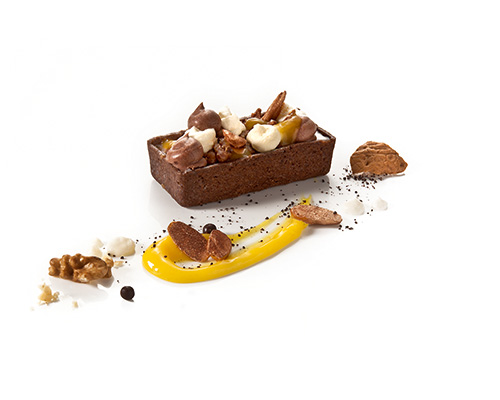 Walnut chocolate tart deluxe crispy chocolate tart, with walnut ganache, finely balanced with orange gel, chocolate buttercream and caramelised walnuts, 3.3 x 7.3 cm.