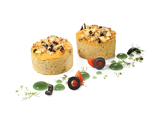 Nuss-Polenta-Törtchen mit Hirtenkäse, Haselnüssen und Mandeln, verfeinert mit schwarzen Oliven.