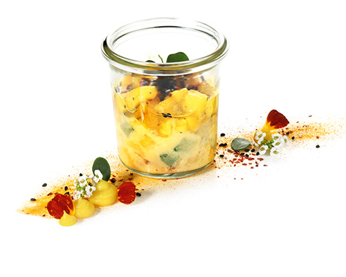 Vegan tuna salad with mango chutney vegan tuna substitute based on algae and pea protein in sesame mayonnaise and mango chutney, refined with chilli and coriander, in a tall preserving jar.