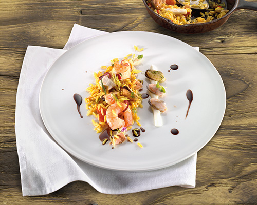 Paella de luxe with prawns, chicken breast, noble fish and saffron.