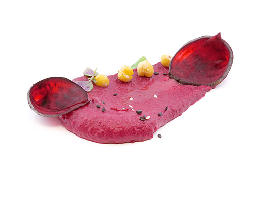 Veganer Rote-Bete-Hummus verfeinert mit Tahina und geröstetem Sesamöl.