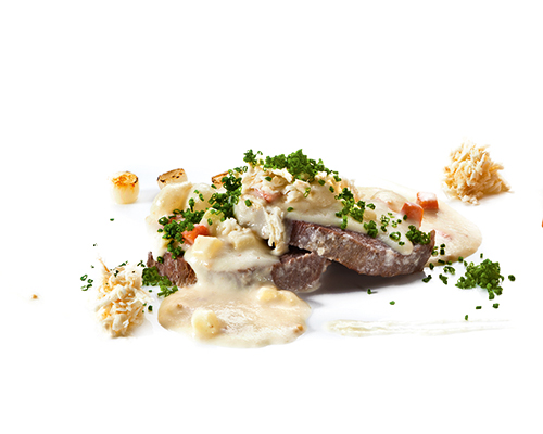 Zartes Rindfleisch mit Perlzwiebeln, Äpfeln und Karotten, in Meerrettichsauce, in Scheiben geschnitten.