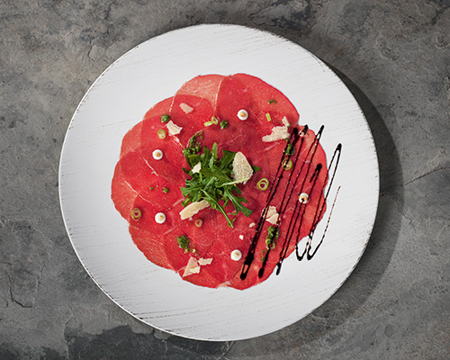 Rindercarpaccio geschnitten, rund gefächert, aus der Semerrolle, auf Folie.