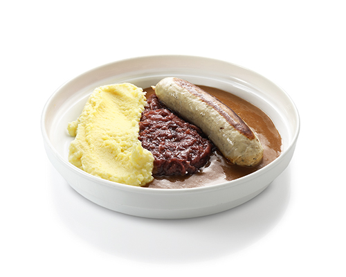 Bratwurst in gravy served with red cabbage and mashed potatoes.