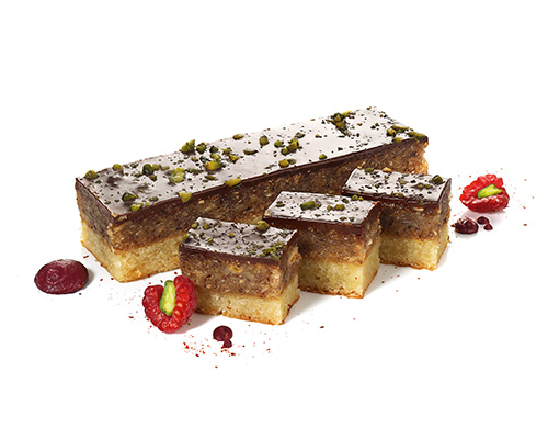 Nussschnitte aus Mandeln, Haselnüssen und Aprikosen, auf Mürbeteig, mit Schokoladen-Ganache-Spiegel, 4 x 18 cm.