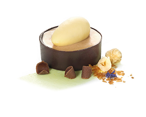 Schokoladen-Nougat-Tarte zartschmelzende Nougatmousse mit gerösteten Nüssen, im knusprigen Schokoladen-Tartelette,  mit einer Eierlikör-Nocke.