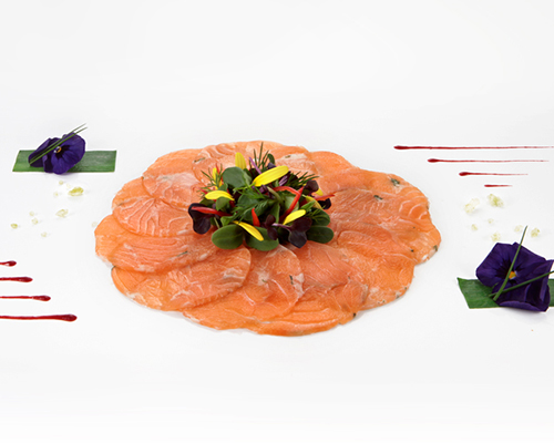Carpaccio vom Lachs roh, geschnitten und rund gefächert, auf Folie.