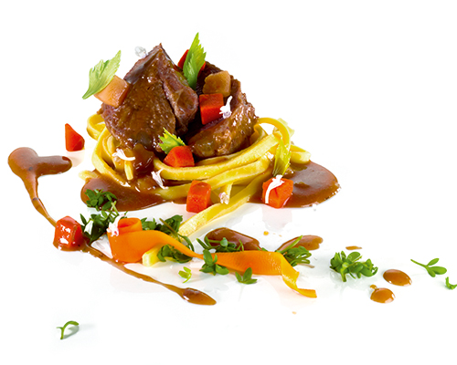 Geschmorte Ochsenbäckchen mit Wurzelgemüse, in Portweinsauce.