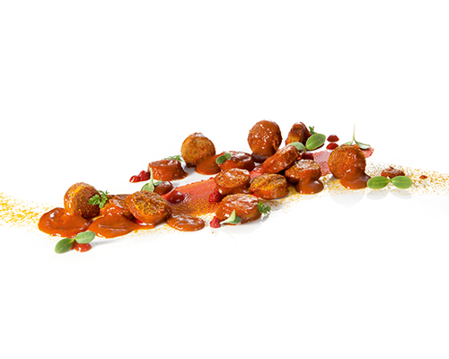 Pork currywurst in a fruity, spicy sauce with cola and apple sauce.