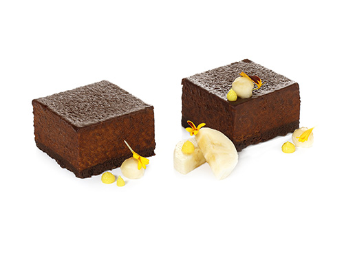 Bananen-Schoko-Cheesecake mit Mascarpone und Vanille, auf knusprigem Boden, im Schokoladenmantel, 4,5 x 4,5 cm.
