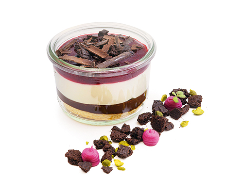 Black Forest Kirsch "Sander Style" white mousse with kirsch on chocolate ganache, with a fruity cherry layer and a topping of cookies and chocolate shavings, in a large glass.