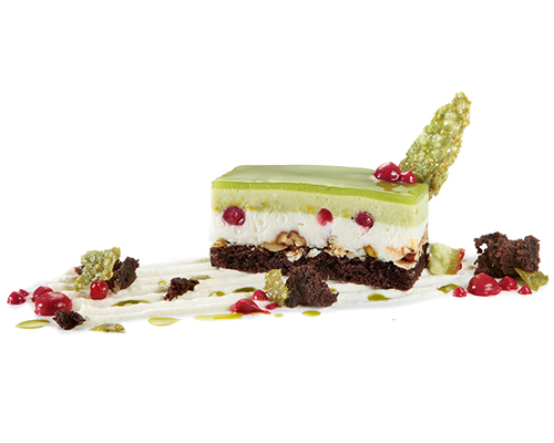 Pistachio-Yoghurt Delight light yoghurt mousse and savoury pistachio cream on a nutty chocolate base, 3 x 7 cm.