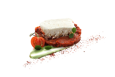 Feta auf orientalischer Tomate Schafskäse auf kräftigem Tomatenkompott, verfeinert mit Cumin, Basis für eine Tellervorspeise.