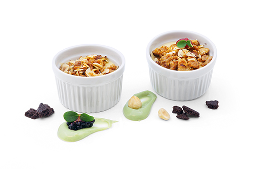 Sanders Heiße Liebe Vanillecreme mit Schmand, Himbeeren und Schokoladenstreuseln und einem Topping aus karamellisierter weißer Schokolade mit Haselnüssen, Im Souffléförmchen.