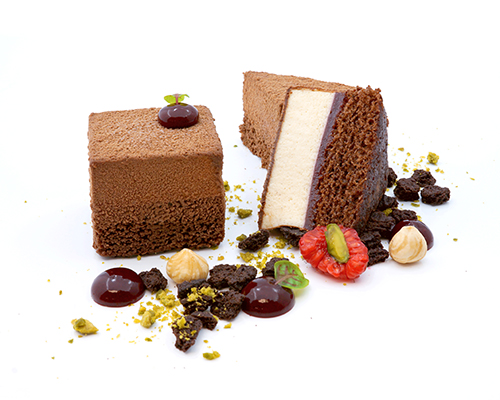 Dominostein "Sander-Style" aus Marzipanmousse mit Vanille und Zimt, mit einer Orangen-Preiselbeer-Schicht,  auf saftigem Lebkuchenbiskuit, 4 x 4 cm.