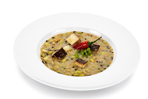 Vegan lentil and vegetable stew with potatoes and smoked tofu.