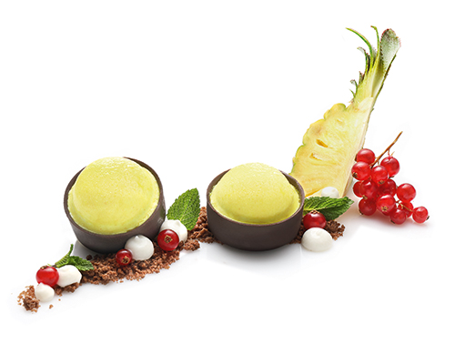 Mus kokosowy Pina Chocolata z pianką ananasową w chrupiącej czekoladowej tarteletce o średnicy 5 cm.